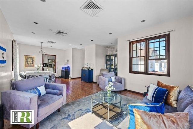 living area featuring visible vents, wood finished floors, and a healthy amount of sunlight