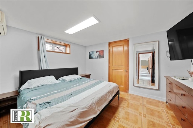 bedroom with baseboards and a wall mounted air conditioner