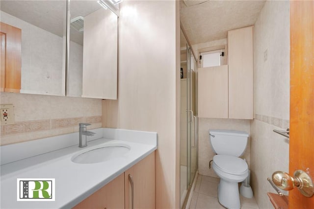 bathroom with visible vents, toilet, vanity, a shower stall, and tile patterned flooring