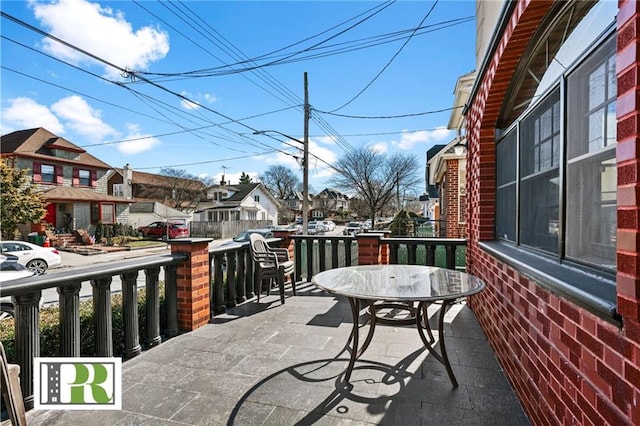 balcony featuring outdoor dining space and a residential view