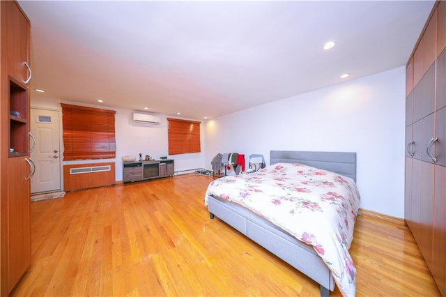 bedroom with a wall mounted air conditioner, light wood finished floors, recessed lighting, and radiator heating unit