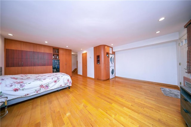 bedroom with estacked washer and dryer, light wood-style floors, and recessed lighting