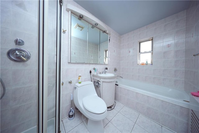 full bathroom featuring tile patterned flooring, a tile shower, tile walls, and toilet