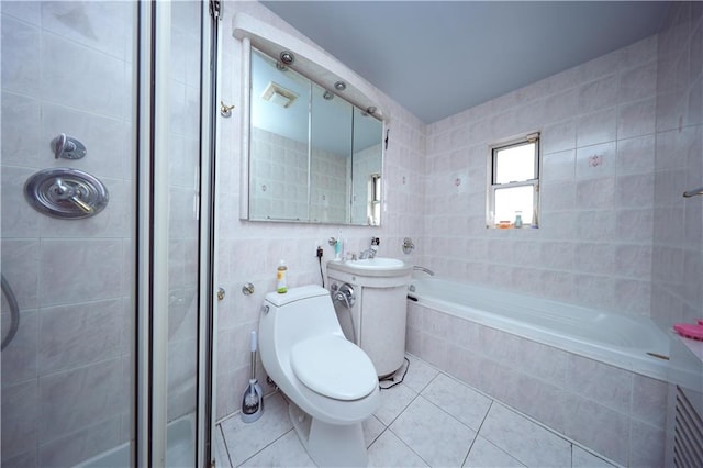 full bathroom with a tile shower, tile walls, a relaxing tiled tub, tile patterned flooring, and toilet