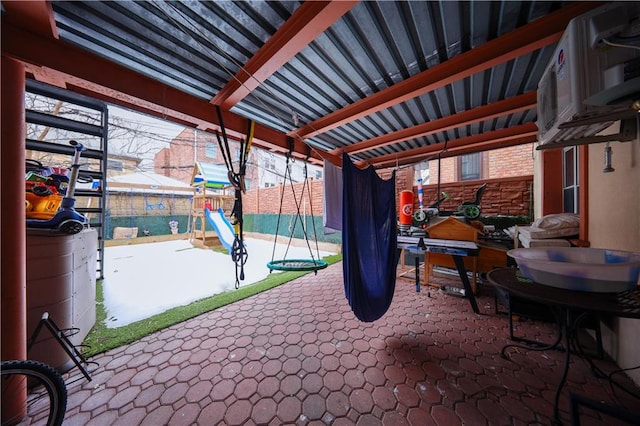 view of patio featuring a playground and fence