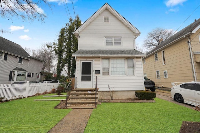 view of front of property featuring entry steps, a front yard, and fence