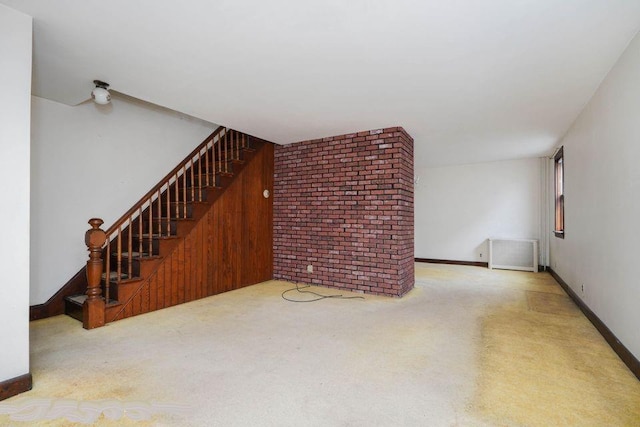 unfurnished living room with baseboards, stairs, and carpet