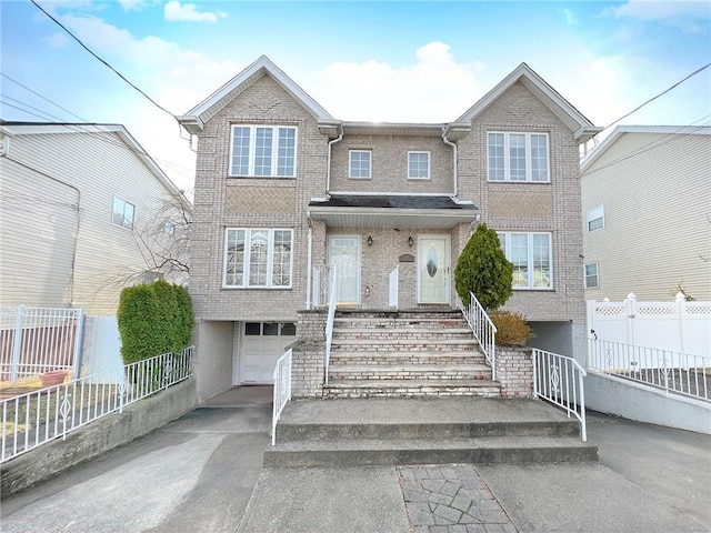 townhome / multi-family property featuring brick siding, concrete driveway, a garage, and fence