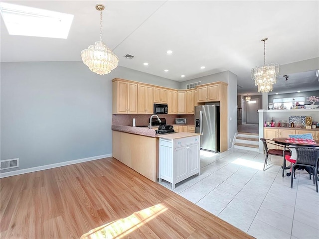 kitchen with range with gas cooktop, black microwave, a notable chandelier, and stainless steel fridge with ice dispenser