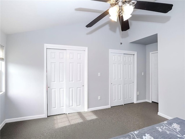 unfurnished bedroom with multiple closets, vaulted ceiling, carpet floors, and baseboards