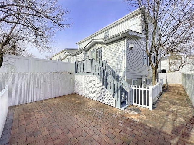 view of side of home with a fenced backyard and a patio