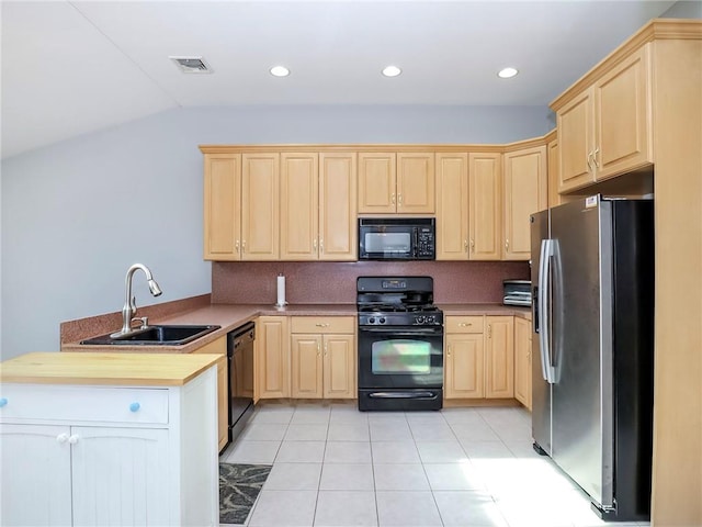 kitchen featuring light brown cabinets, a peninsula, a sink, visible vents, and black appliances