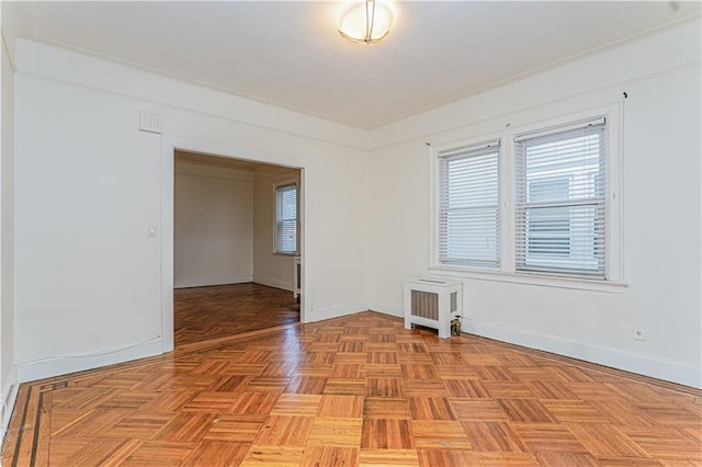 spare room featuring baseboards and radiator