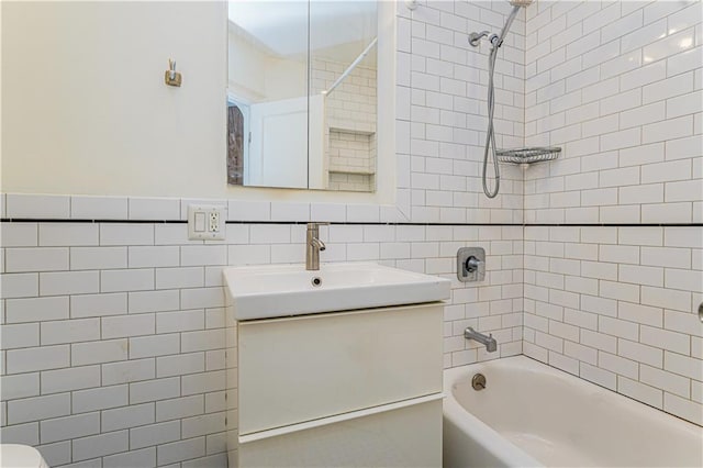 full bath featuring  shower combination, tile walls, vanity, and toilet