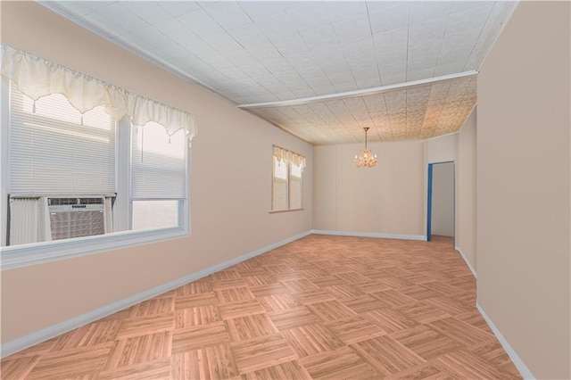 empty room with an inviting chandelier, baseboards, and cooling unit