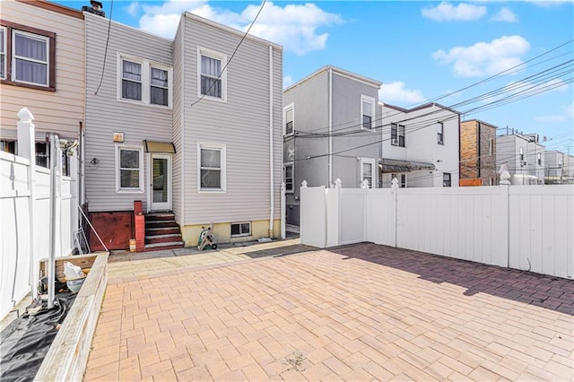 back of house featuring entry steps, a fenced backyard, a residential view, and a patio