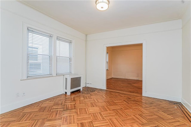 empty room featuring radiator heating unit and baseboards