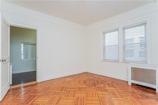 spare room featuring baseboards and radiator heating unit