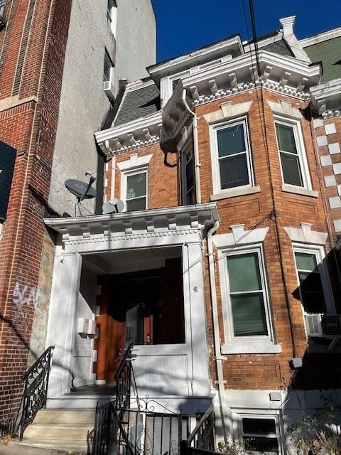 view of front of house with cooling unit and brick siding