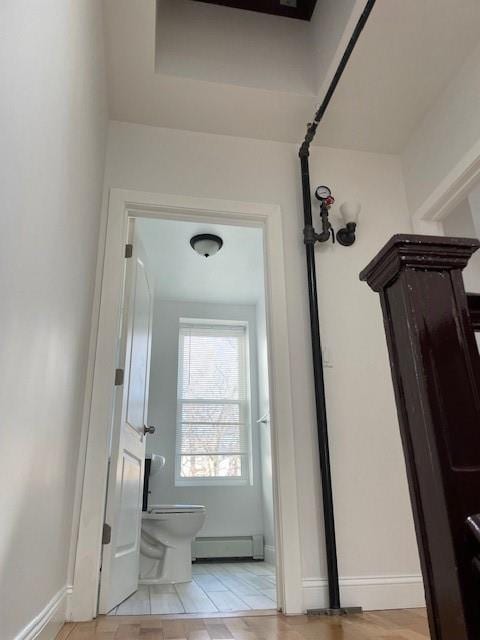 doorway featuring a baseboard radiator and baseboards