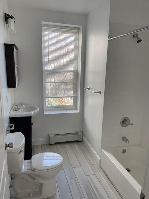bathroom featuring washtub / shower combination, vanity, a baseboard heating unit, toilet, and wood tiled floor