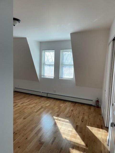 bonus room featuring a baseboard radiator and wood finished floors