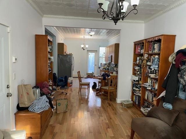 interior space featuring crown molding, light wood finished floors, and a notable chandelier