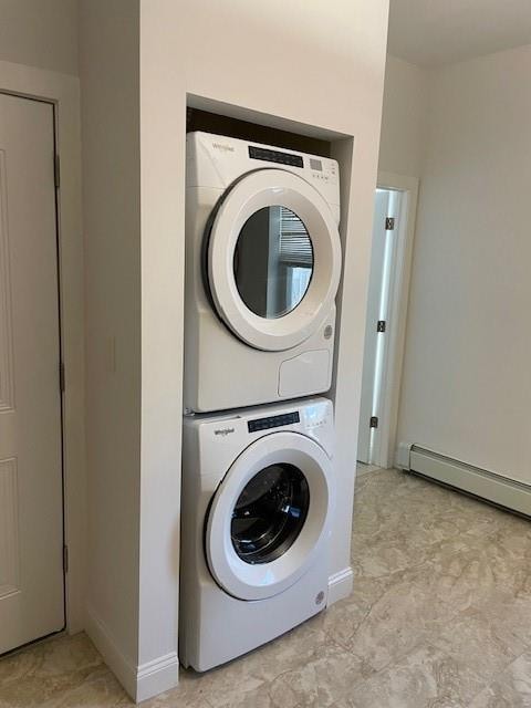 laundry room featuring a baseboard heating unit, stacked washer and dryer, baseboards, and laundry area