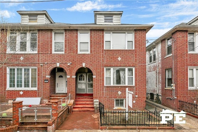 view of front of house with a fenced front yard and brick siding