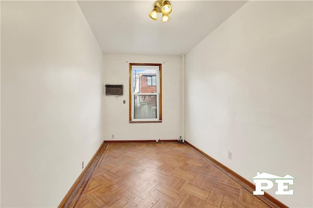 empty room with baseboards and a wall mounted AC