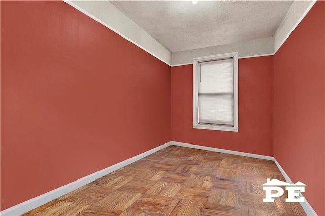 unfurnished room featuring a textured ceiling and baseboards