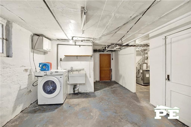 unfinished basement featuring washer / dryer and a sink