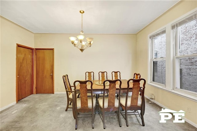 carpeted dining room with a notable chandelier and baseboards