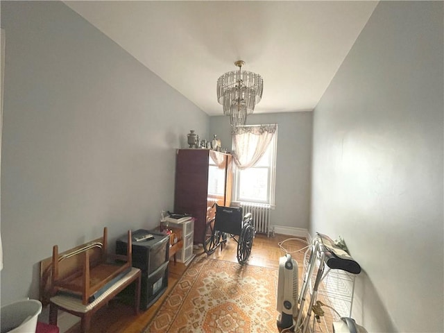 dining space featuring a chandelier, baseboards, and radiator heating unit