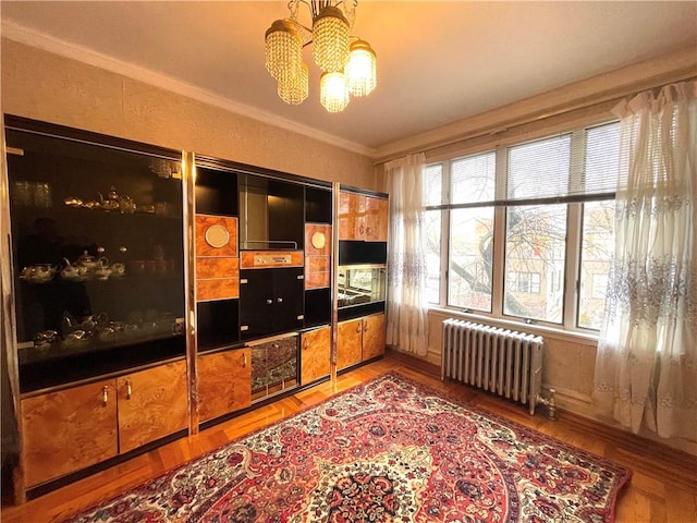 interior space featuring crown molding, light wood-type flooring, an inviting chandelier, and radiator