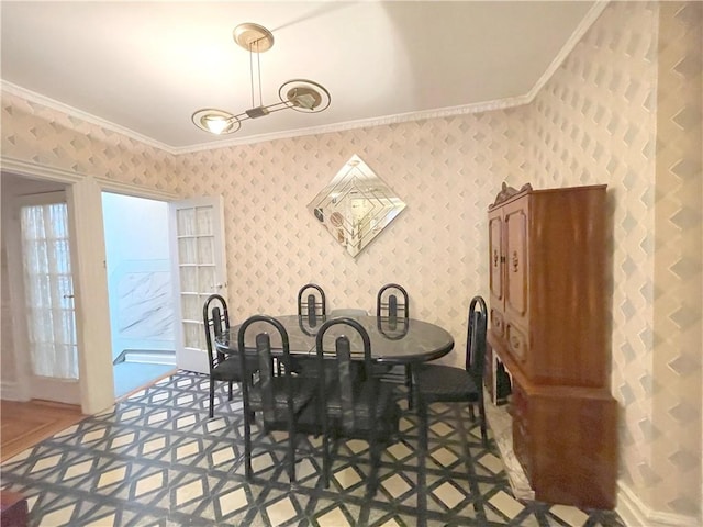 dining room featuring ornamental molding and wallpapered walls