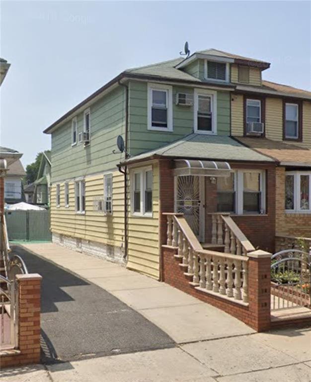 view of front facade featuring driveway, a gate, fence, and cooling unit