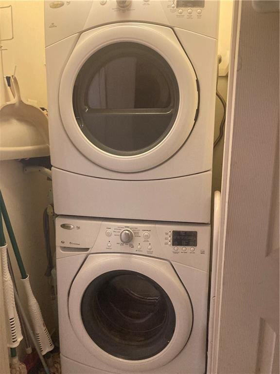 laundry area featuring stacked washer / drying machine and laundry area