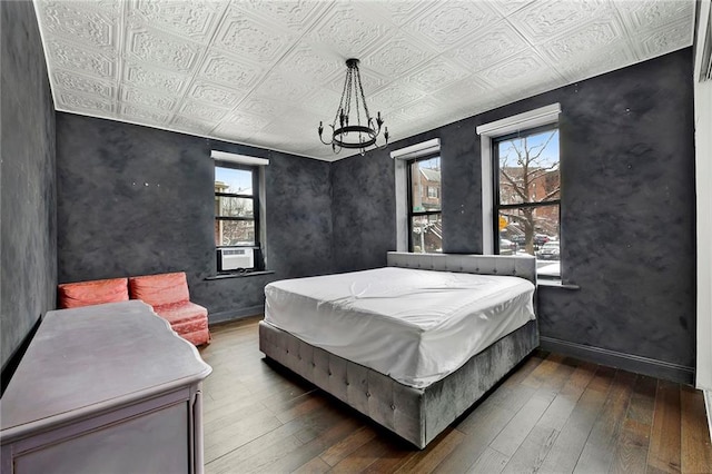 bedroom with an ornate ceiling, baseboards, and dark wood finished floors