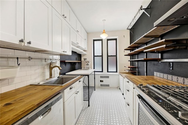 kitchen featuring butcher block counters, a sink, white cabinetry, open shelves, and pendant lighting