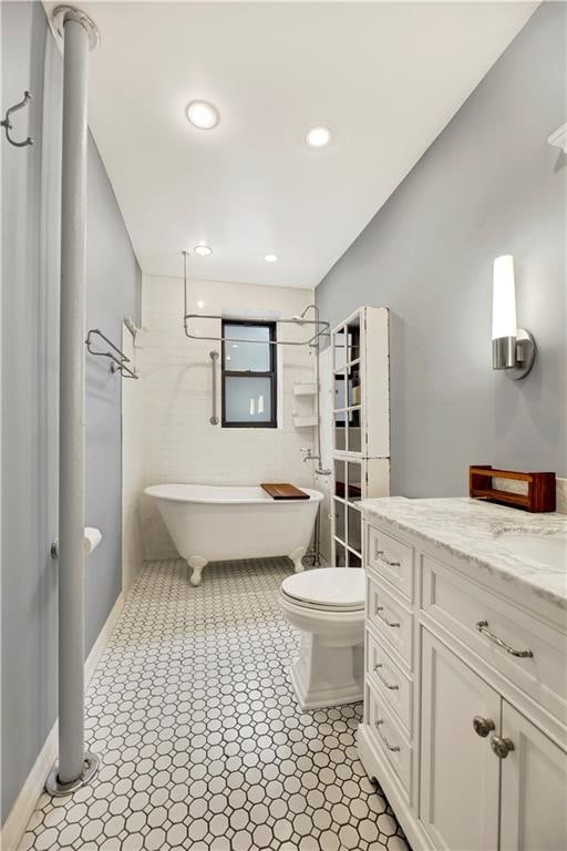 bathroom with recessed lighting, a soaking tub, toilet, vanity, and walk in shower