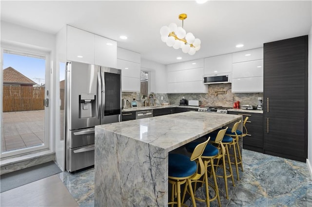 2511 Ocean Ave Unit 201, Brooklyn, NY 11229 - kitchen with stainless steel appliances, modern cabinets, a kitchen island, pendant lighting, and white cabinetry