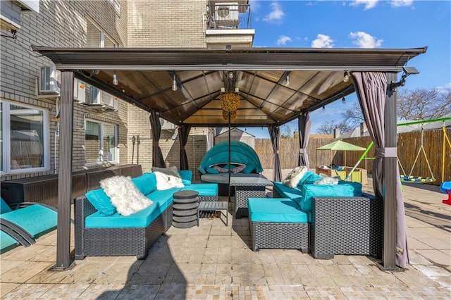 view of patio with an outdoor hangout area, a gazebo, and fence