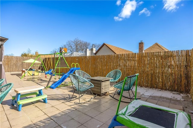 view of patio / terrace with a fenced backyard and a playground