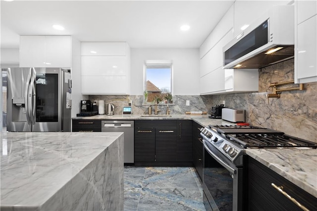 kitchen featuring modern cabinets, appliances with stainless steel finishes, white cabinets, and a sink