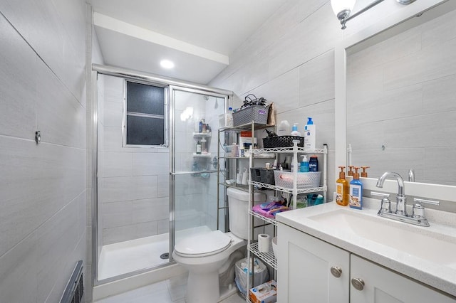 full bathroom featuring vanity, a shower stall, toilet, and tile walls