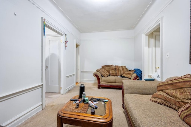 living area featuring baseboards, ornamental molding, and light colored carpet