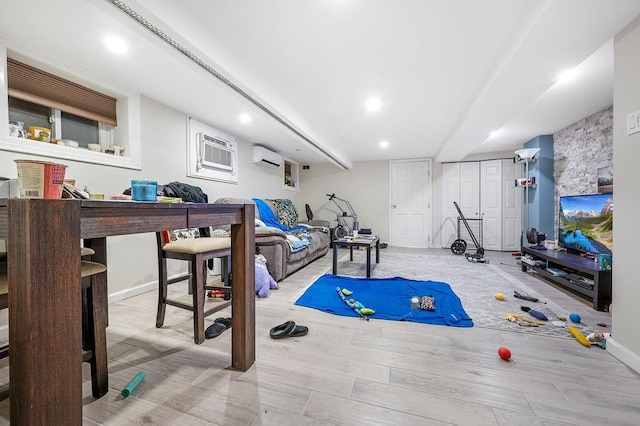 workout area featuring a wall unit AC, wood finished floors, and a wall mounted air conditioner