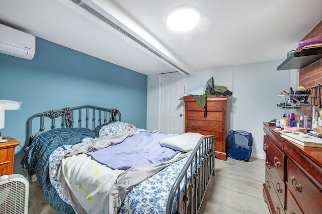 bedroom featuring a wall mounted air conditioner and light wood-style floors