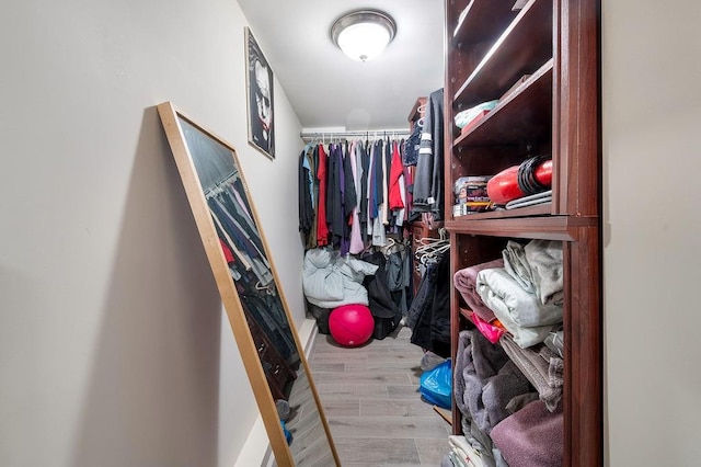 walk in closet with wood finished floors